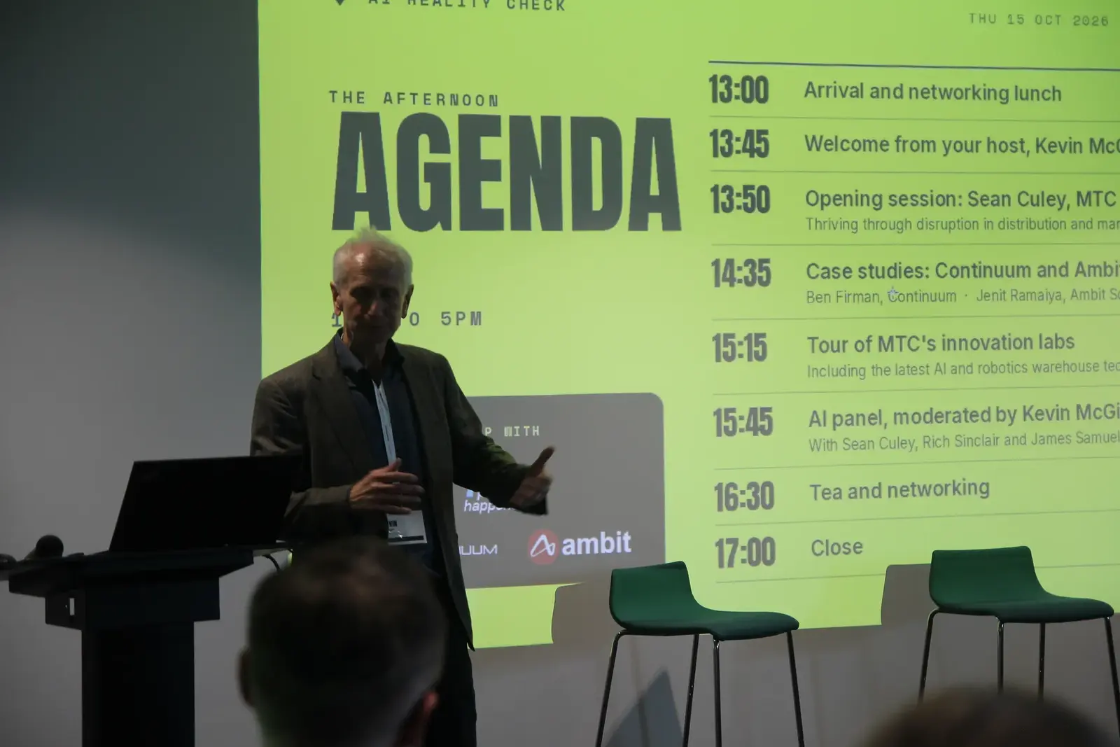 Host Kevin McGirl beside the lime-green agenda slide